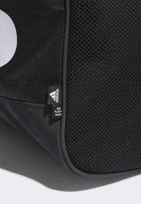 Borsa sportiva nera con tessuto a rete, texture liscia, bordi arrotondati, con etichetta del logo Adidas e etichetta "End Plastic Waste".