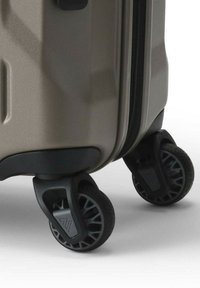 Hartschalen-Koffer in hellgrau mit strukturierter Oberfläche. Verfügt über schwarzes Kunststoffbeschlag und vier multidirektionale Rollen.