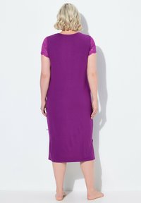 Camisón morado con mangas cortas de encaje, diseño hasta la rodilla, escote redondo y aberturas laterales para facilitar el movimiento. Tejido suave y liso.