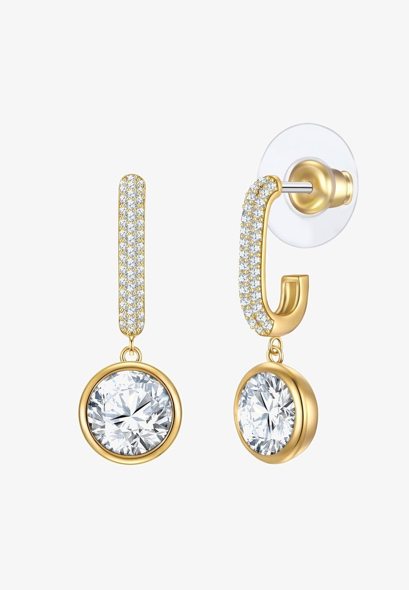 Zlate uhane, ki imajo teksturirano zgornjo površino s prozornimi kamni in velikim okroglim kristalom na dnu. Zavarovani so s prozornim podstavkom.