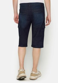 Shorts cargo en denim foncé avec poches, longueur genou et coupe droite ; dotés de passants de ceinture et d'une légère décoloration.