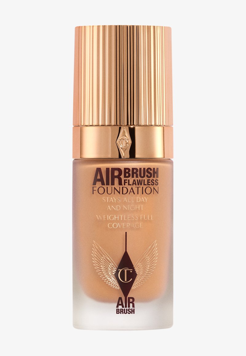 Airbrush Flawless Foundation in a glass bottle. Gold ribbed cap and label with dark text. Smooth, light tan liquid visible inside.
