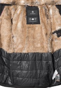 Brown faux fur inner lining with black quilted exterior. Features a hangtag and pockets, showcasing a mix of textures and layered design.