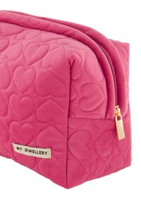 Roze gewatteerde cosmetica tas met hartpatronen, een ritssluiting met gouden hardware, en een label met de tekst "MIJN SIERADEN."