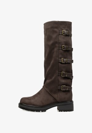 Bota de ante marrón hasta la rodilla que presenta cuatro correas marrones ajustables con hebillas y una suela texturizada negra. Tacón ancho para mayor estabilidad.