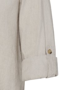 Manche longue beige avec un revers roulé maintenu par un seul bouton marron clair sur une patte en tissu.