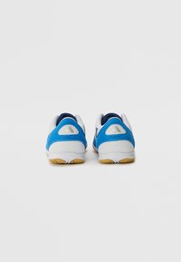 Zapatillas deportivas en azul y blanco con una parte superior de malla texturizada, cuello acolchado y suela de goma, que presentan detalles en gris y un diseño aerodinámico.