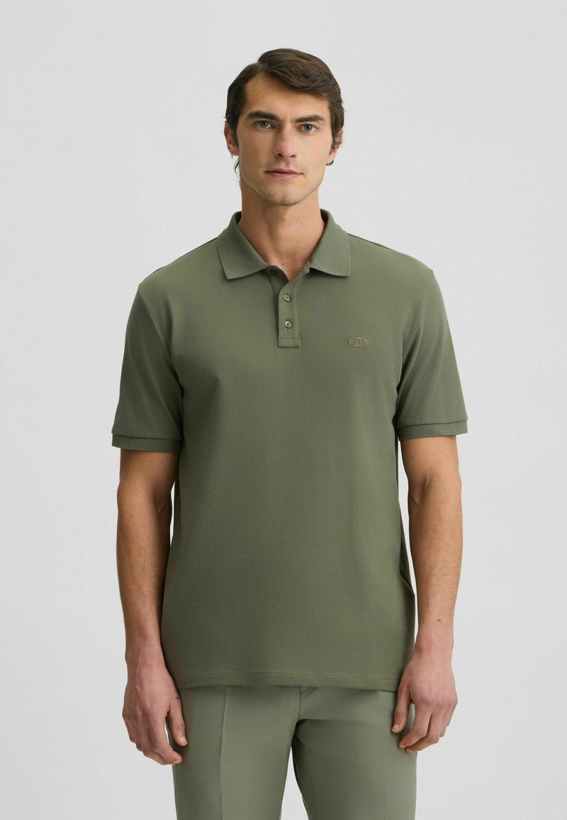Olivgrünes Poloshirt mit kurzen Ärmeln, klassischem Kragen, Knopfleiste mit drei Knöpfen und dezentem Logo auf der Brust. Glattes Baumwollmischgewebe.
