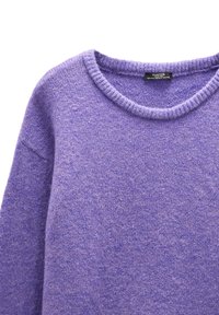 Fioletowy sweter dzianinowy z okrągłym dekoltem, prążkowanym kołnierzem i miękką teksturą. Zawiera metkę wewnątrz z informacjami o marce.