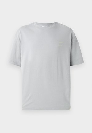 Tricou din bumbac gri cu o croială lejeră, mâneci scurte și un detaliu de text galben mic pe față. Textură moale și decolteu clasic în formă de cerc.