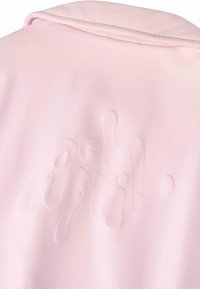 Giacca rosa con una texture liscia e un sottile design in rilievo che riporta la scritta "Aprile" sulla schiena. Il colletto a contrasto aggiunge un tocco di dettaglio.