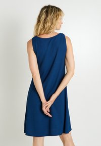 Vestido sin mangas en color azul marino, de tejido texturizado, con escote redondo y un corte relajado, que llega justo por encima de las rodillas.