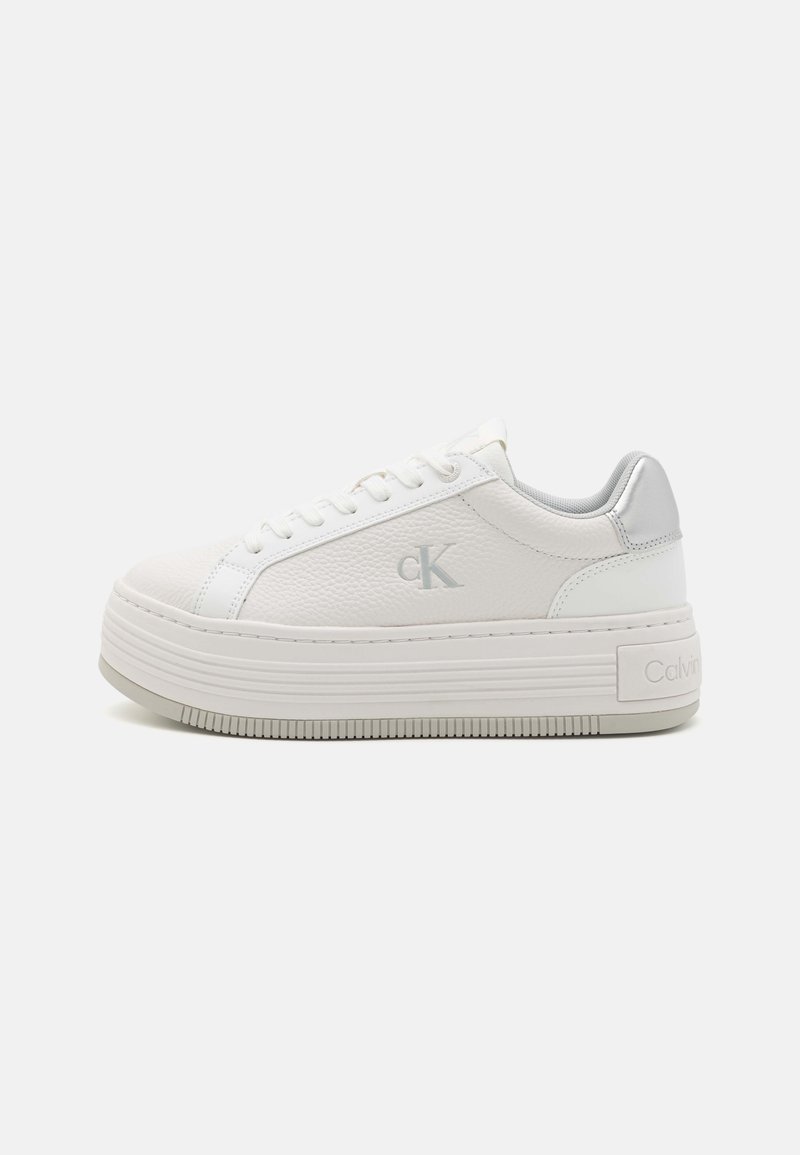 Vita plattformsneakers med strukturerad läderöverdel, silverdetaljer och gummisula. Har snörning och subtil logotypdetalj.