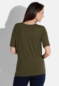 Korte mouw blouse in donkergroen met een geometrisch mosterdpatroon, voorzien van een ronde halslijn en een gladde, lichte stof.