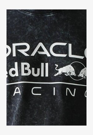Schwarzer Stoff mit weißem "Oracle Red Bull Racing"-Text und Logo, das zwei sich gegenüberstehende Bullen in einem Kreis zeigt.