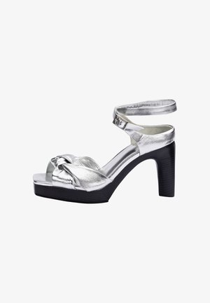 Sandale argentée à talons hauts avec boucle de sangle à la cheville, design noué à l'avant et semelle plateforme noire épaisse.