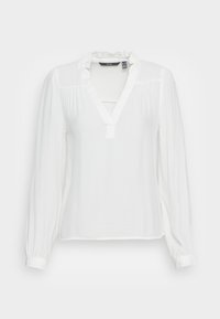 Blusa bianca a maniche lunghe con colletto arricciato, scollatura a V e dettagli arricciati sulle spalle. Realizzata in tessuto leggero e testurizzato.