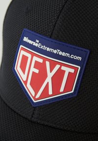 Czarna czapka wykonana z teksturowanej tkaniny, z niebieską i czerwoną łatą z logo oraz białym napisem "DEXT" i "DiverseExtremeTeam.com".