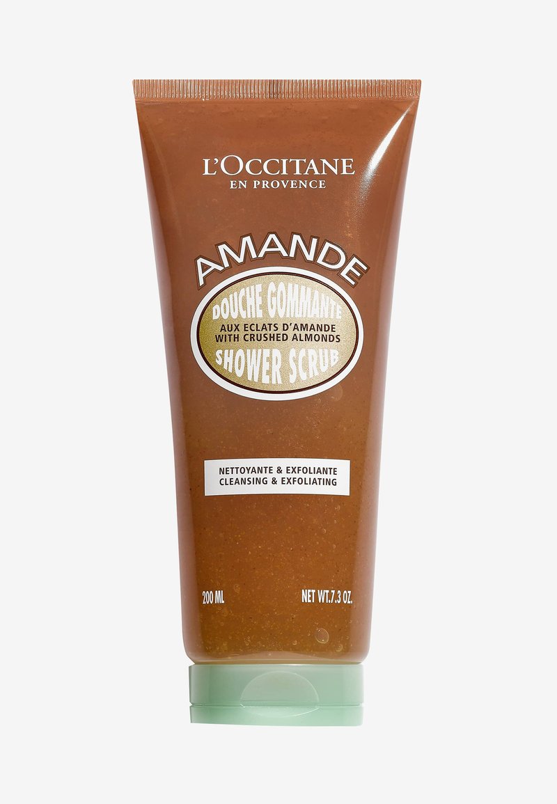 Tubo schiacciabile marrone con tappo verde chiaro. L'etichetta riporta "AMANDES" in caratteri bianchi e dorati. Contiene scrub da doccia con mandorle tritate. 200 ml.