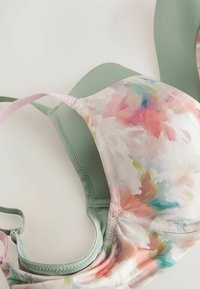 Blomstermønstrede bh med pastelfarver, der har en glat grøn bund og bløde lyserøde stropper. Inkluderer strukturerede syninger.