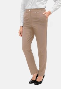Beige op maat gemaakte broek met een rechte pijp, zijzakken en een knoopsluiting. Gekocht met een wit overhemd en zwarte hoge hakken.
