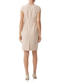 Knie-langes, hellbeiges Kleid mit kurzen Ärmeln, Reißverschluss hinten und einer zentralen Naht. Es hat eine taillierte Silhouette und einen leichten Schlitz am Saum.