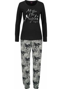 Black long-sleeve top with silver text "All thru the Night," paired with loose-fitting floral print pants in black and white.