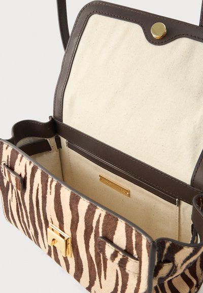 Τσάντα χειρός με ρίγες ζέβρας, χρυσό κούμπωμα, σκούρο καφέ δερμάτινη επένδυση και μπεζ υφασμάτινη εσωτερική επένδυση, ανοιχτή με ορατό λουράκι.