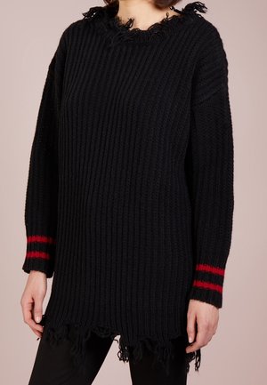 Sort chunky strikket sweater med slidt kant og halsudskæring, med to røde striber på hver ærmekant.