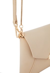 Borsa in finta pelle beige con design strutturato, dotata di una cerniera e accessori dorati, e una sottile tracolla removibile.