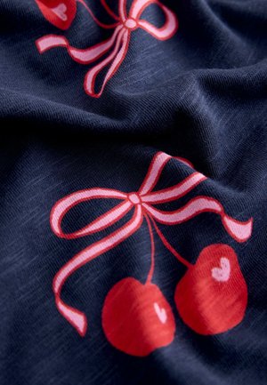 Granatowy materiał z nadrukiem czerwonych wiśni z akcentami w kształcie serc i różowymi kokardami. Tkanina ma miękką fakturę i subtelny połysk.