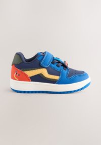 Baskets synthétiques bleu et marine avec bride auto-agrippante, accents jaunes et rouges, détail de visage ludique, et semelle en caoutchouc texturée.