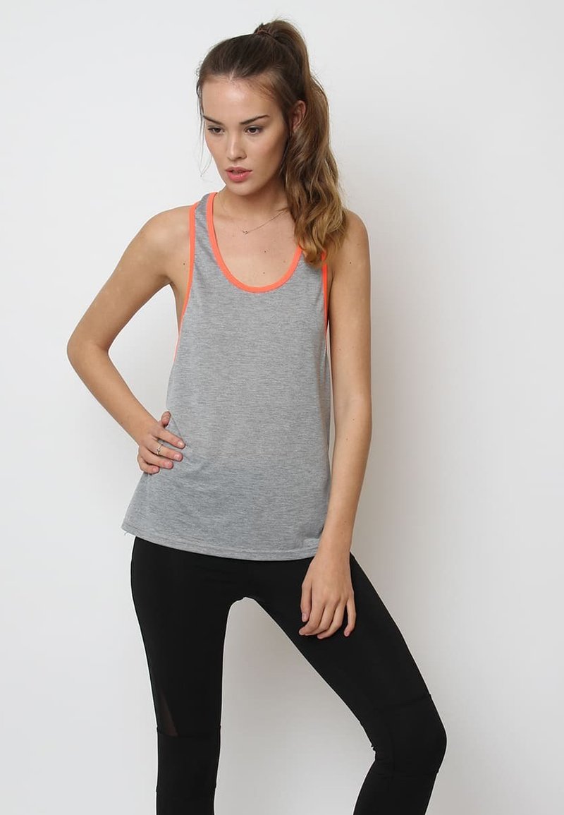 Camiseta sin mangas gris con ribete naranja, hecha de tela ligera. Tiene un corte relajado y un escote redondeado, combinada con leggings negros.