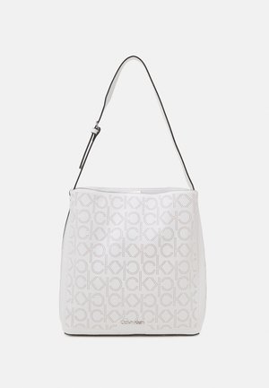 White Calvin Klein shoulder bag with perforated CK logo pattern and adjustable strap on light background.