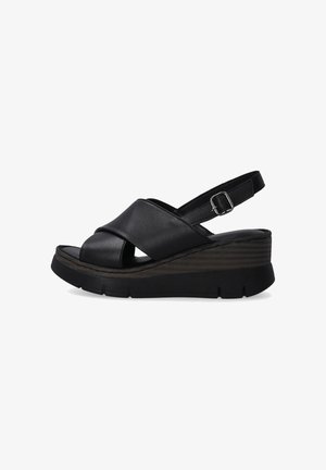 Schwarze Wedge-Sandalen mit überkreuzten Lederriemen, offener Zehenpartie, verstellbarem Schnallenverschluss und strukturiertem Plateau. Flache Gummisohle für Stabilität.