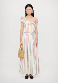 Vestido maxi em branco com padrões verticais de várias cores. Apresenta um ombro com babado, laço na cintura e tecido leve.