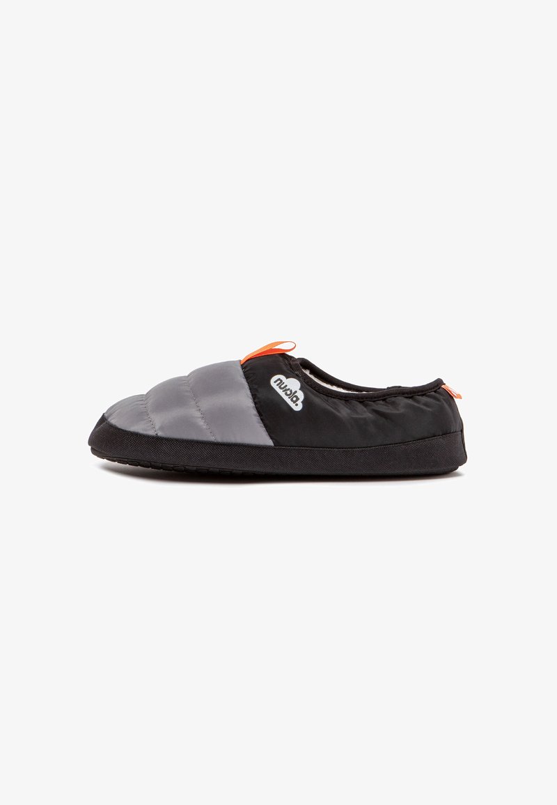 Pantuflas acolchadas en gris y negro con suela de goma negra y un lazo de acento naranja. Exterior de tejido suave, diseño de perfil bajo para uso en interiores.