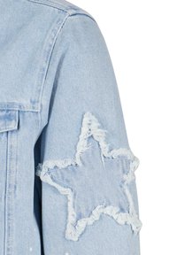 Light blue denim jacket with frayed star patch on sleeve. Features classic collar and button closure; fabric has a textured weave.