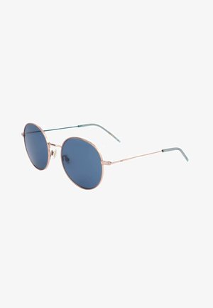 Occhiali da sole rotondi con sottili montature in metallo dorato e lenti blu scuro mostrati su sfondo bianco.