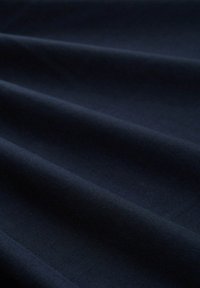 Granatowa tkanina o gładkiej fakturze, z delikatnymi fałdami i jednolitym wzorem splotu. Nadaje się do różnych zastosowań tekstylnych.