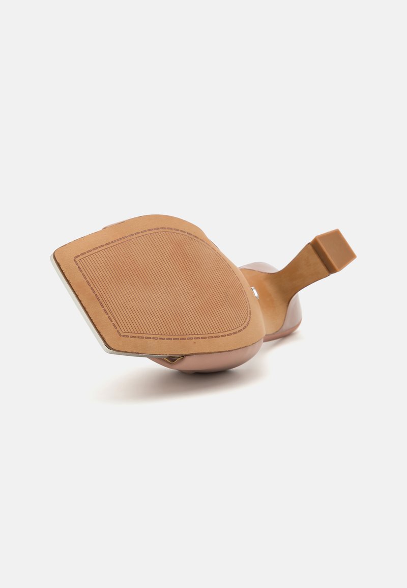 Beżowe szpilki z kwadratowym noskiem i paskiem wokół kostki. Górna część z gładkiej skóry i teksturowana gumowa podeszwa z wzorzystym spodem.