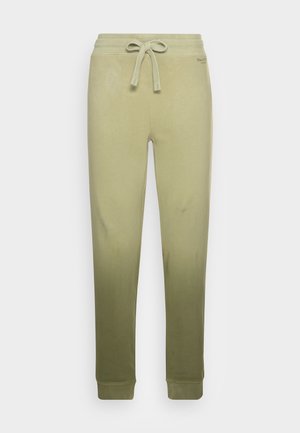 Pantaloni della tuta beige a vestibilità aderente con vita elastica e coulisse frontale, caviglie affusolate e logo discreto vicino alla vita.