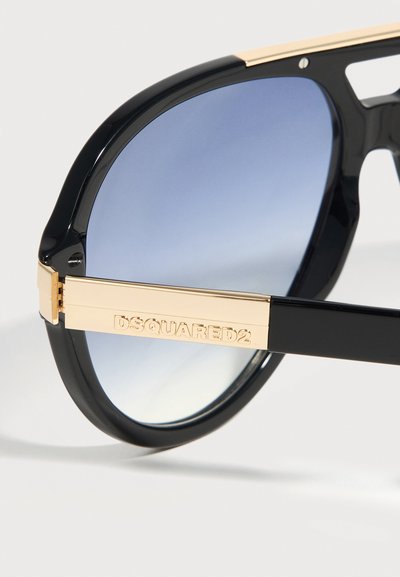 Μαύρα γυαλιά ηλίου με φακούς μπλε διαβάθμισης και χρυσαφί μπράτσα με ανάγλυφο λογότυπο DSQUARED2.