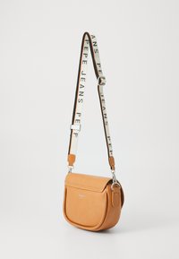 Hnědá kožená crossbody taška s zakřiveným designem. Obsahuje klopnu, nastavitelné ramenní popruhy s nápisem "PEPE JEANS" a stříbrné kovové detaily.