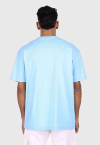 Light blue cotton t-shirt with short sleeves, relaxed fit, and a crew neckline. Smooth texture with no visible patterns or graphics.