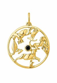 Colgante de oro con un diseño circular que presenta formas de animales intrincadas y una piedra negra central. Superficie suave y pulida.