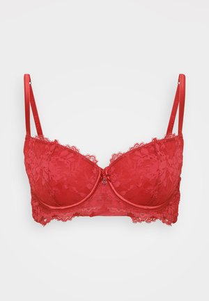 Reggiseno rosso in pizzo con ferretto, coppe imbottite e rifiniture in pizzo decorativo lungo i bordi. Spalline regolabili e dettaglio della chiusura anteriore.