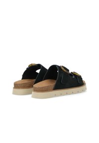 Sandali slip-on in suede nero con due grandi fibbie circolari, suola in sughero e plateau in gomma beige spessa con motivo ondulato.