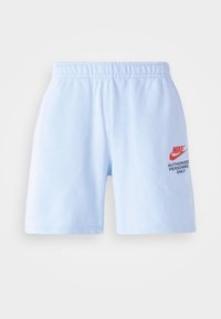 Ljusblå Nike-shorts med elastiskt midjeband och röd logotext "Auktoriserad personal endast" på högra låret.