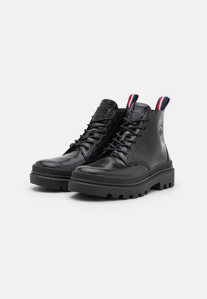 Bottines en cuir noir avec une semelle épaisse, design à lacets, accent rouge et bleu contrasté sur la languette, et marquage en relief sur le côté.